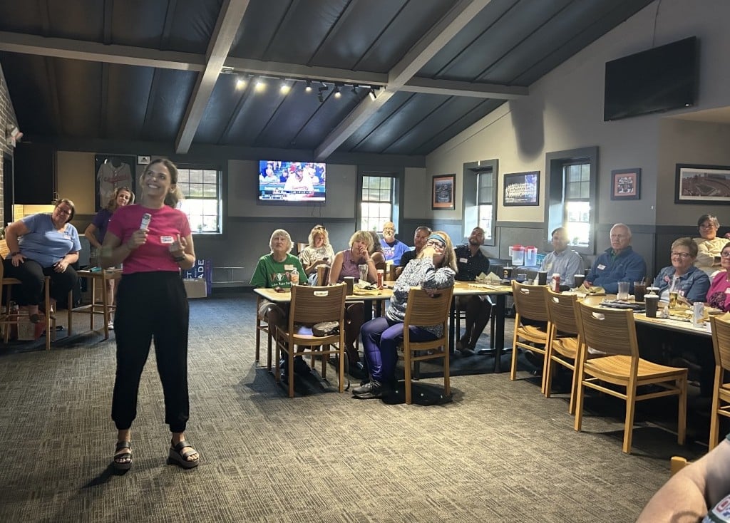 Mario Bruno stands in a room full of Media community members.
