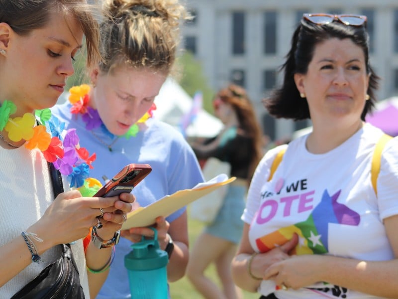 Someone checks their phone while others wear a "Today we VOTE" shirt.