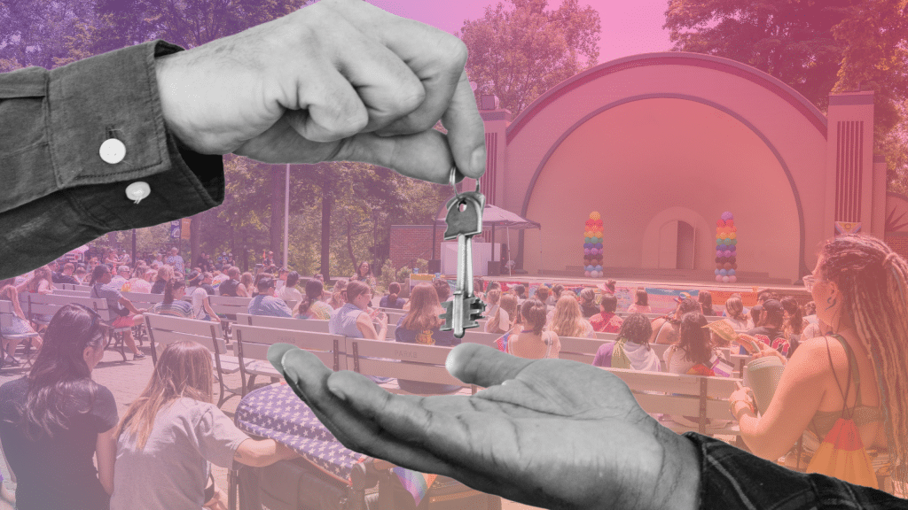 Two people exchange keys in front of a rainbow gradient backdrop of Findlay's Pride in the Park.